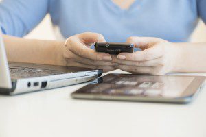 Jersey City, New Jersey, USA --- USA, New Jersey, Jersey City, Close up of woman's hands using multiple devices --- Image by   © Tetra Images/Corbis